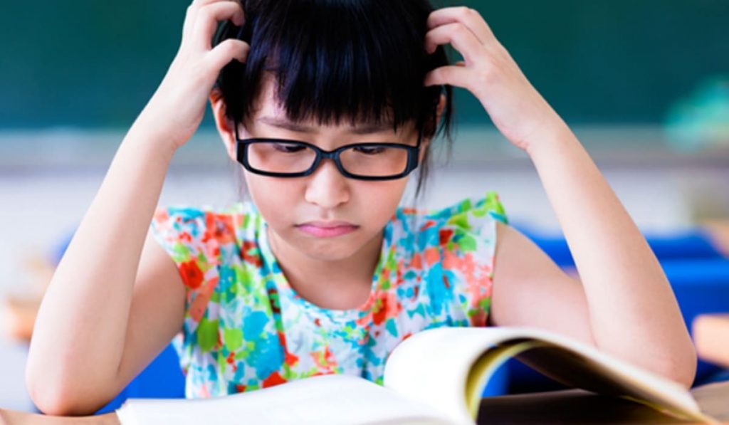 Trẻ cầm sách quá gần mắt khi đọc, dễ làm mắt căng thẳng và tăng nguy cơ cận thị