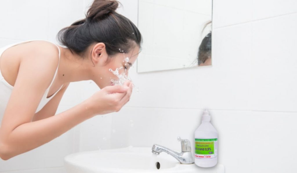 Rửa mắt bằng nước muối 0.9% giúp dịu mắt đỏ và giảm viêm