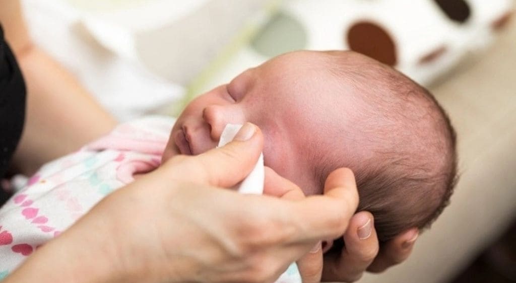 Vệ sinh bằng bông sạch thấm nước muối sinh lý sẽ giúp mắt bé luôn khô thoáng và hạn chế vi khuẩn
