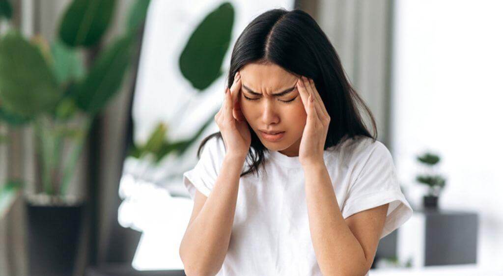 Đau đầu căng thẳng có thể gây cảm giác siết hoặc nặng vùng trán, thái dương và quanh mắt