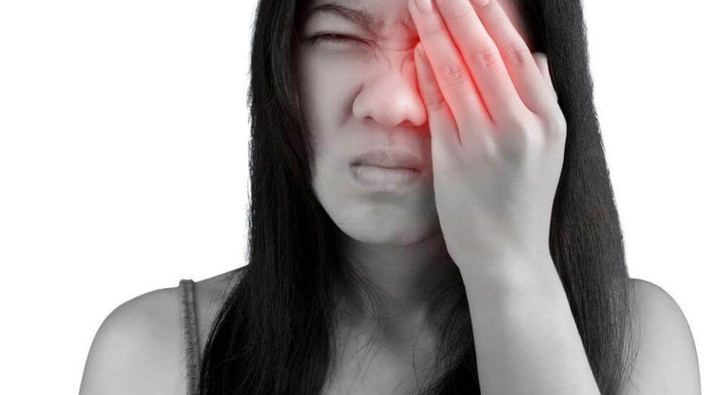 Vùng đuôi mắt trở nên đỏ rực, căng nề, cảm giác cộm như có cát bên trong mắt gây đau